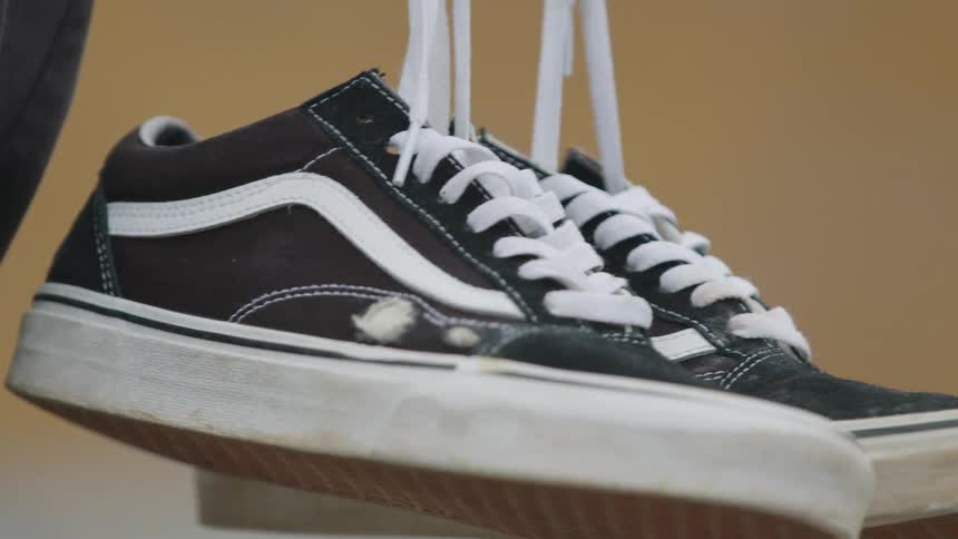 A pair of sneakers dangling by their laces