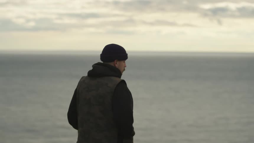 A man walks by the ocean
