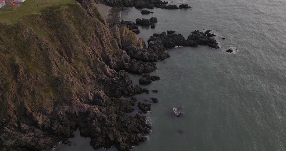 Aerial view of rocky cliffs meeting calm ocean waters