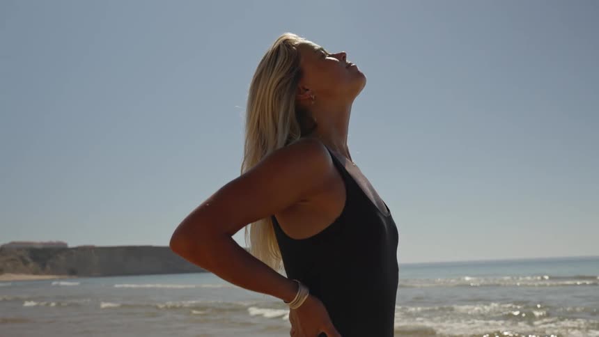 A woman stands on the beach