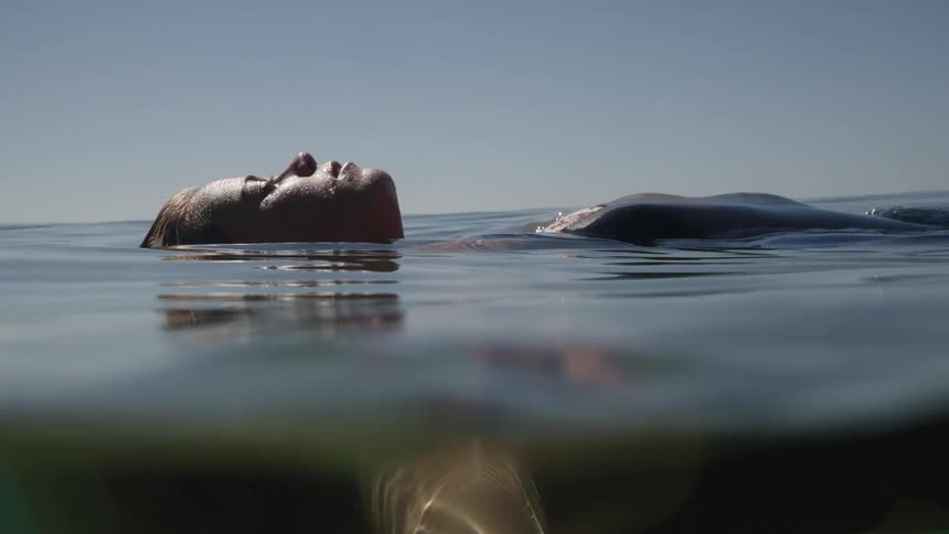 Blonde female floating on her back in the ocean