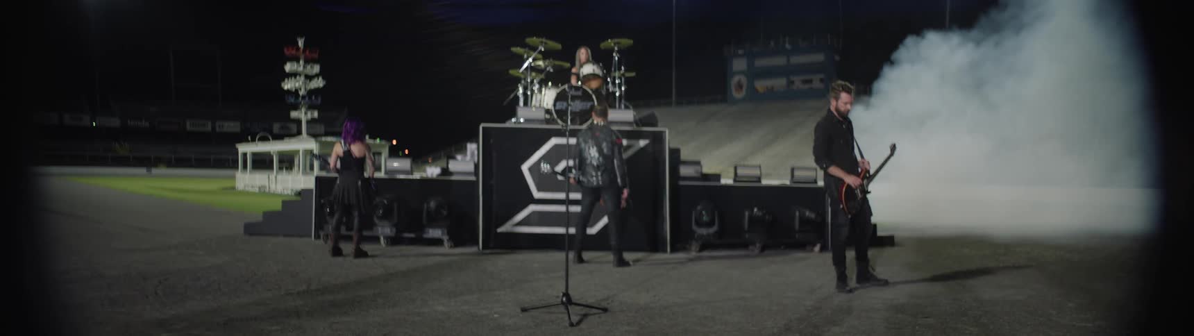 A music band rehearsing on stage in preparation for a concert at night