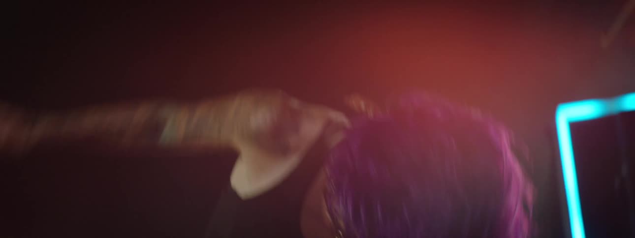 Woman plays electric guitar energetically during a performance