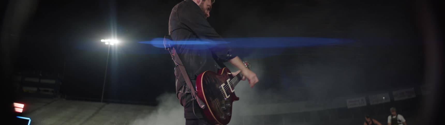 A guitarist plays for a crowd at a night concert