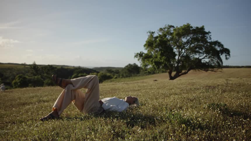 The woman is laying in the grass