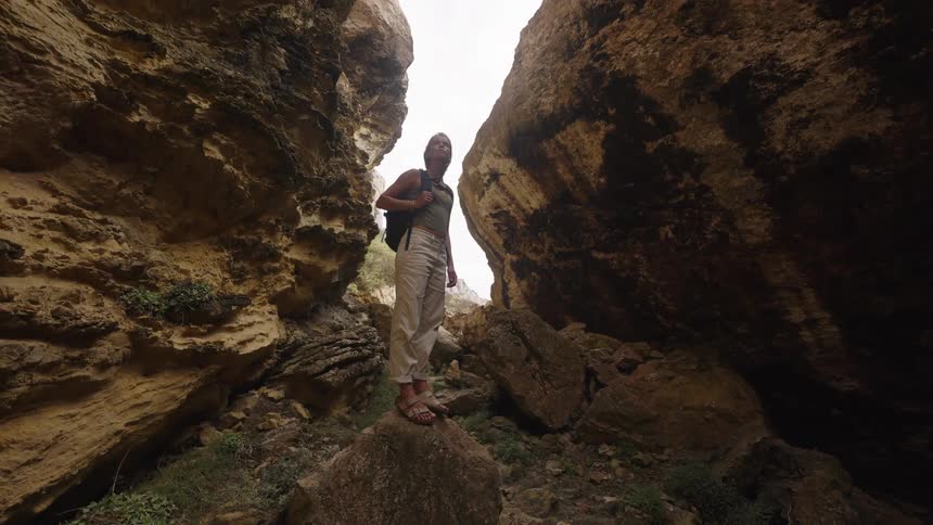 Woman standing on a rock between large stone formations