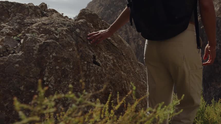 A person walks by some rocks