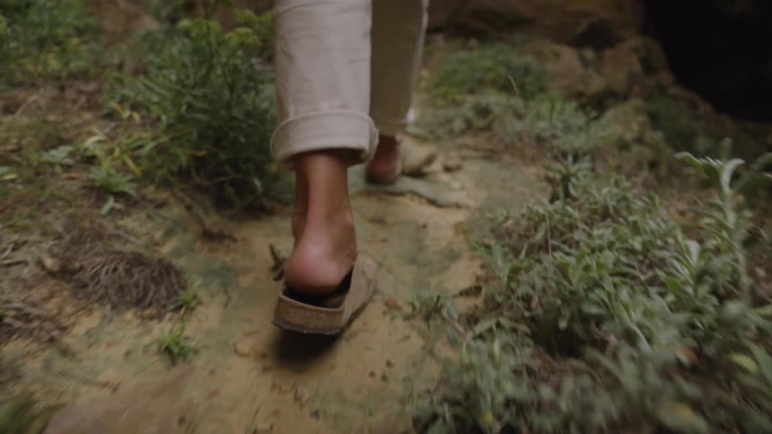 Walking on a natural trail with bare feet touching the ground