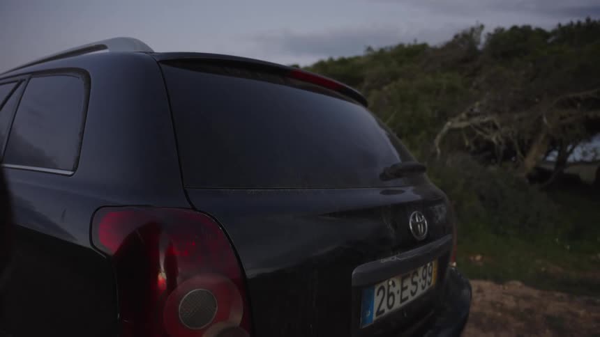 A person opens the trunk of their car