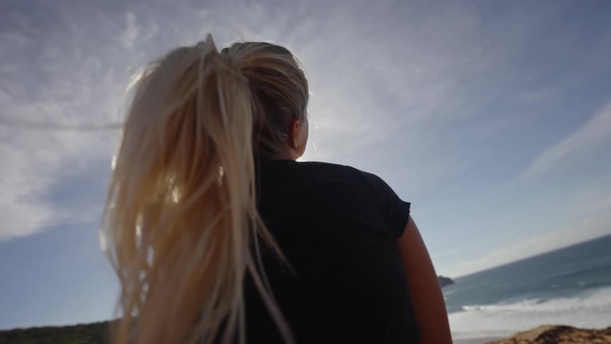 The woman waves her head around by the beach