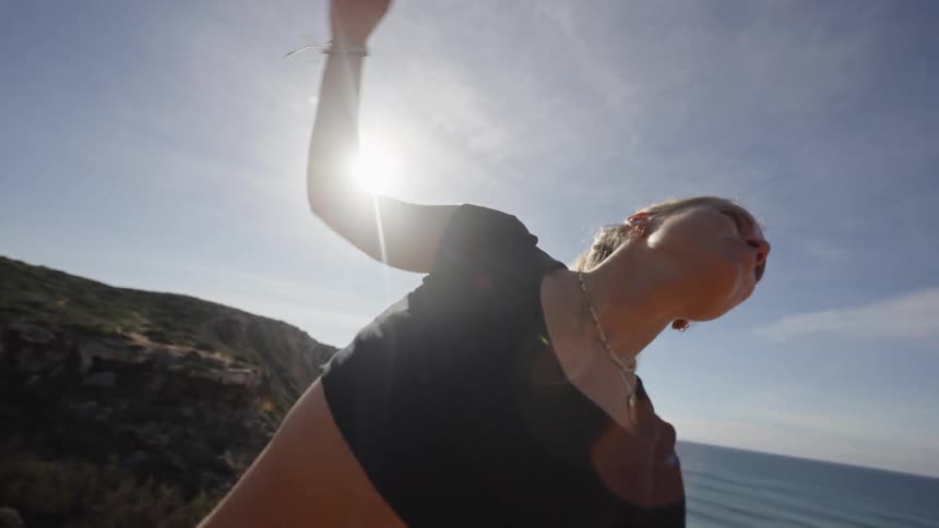 Woman practicing stretching outdoors under the sun