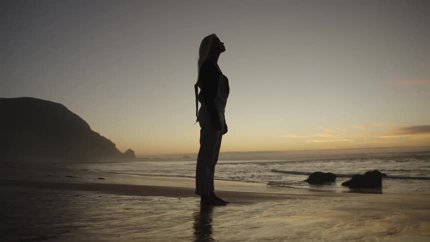 The woman watches the sunrise over the ocean