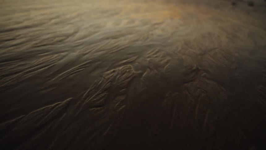 Golden light reflecting on rippled sand surface
