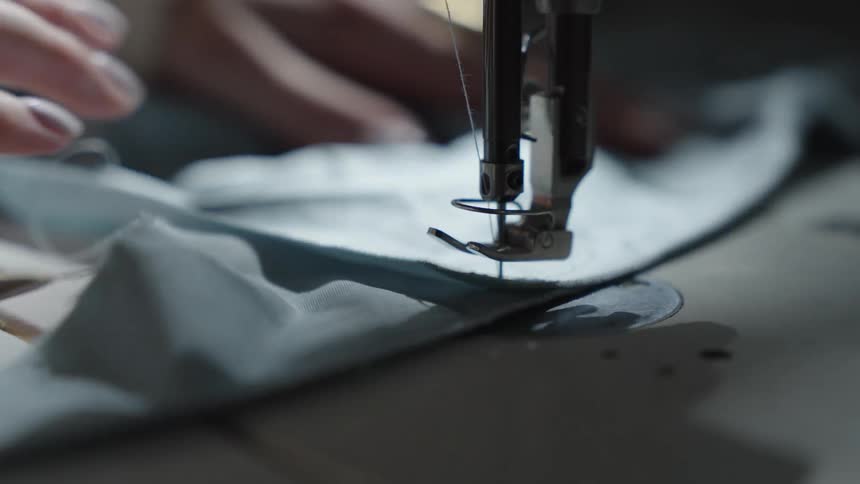 A sewing machine needle stitching fabric showcasing the detailed craftsmanship involved