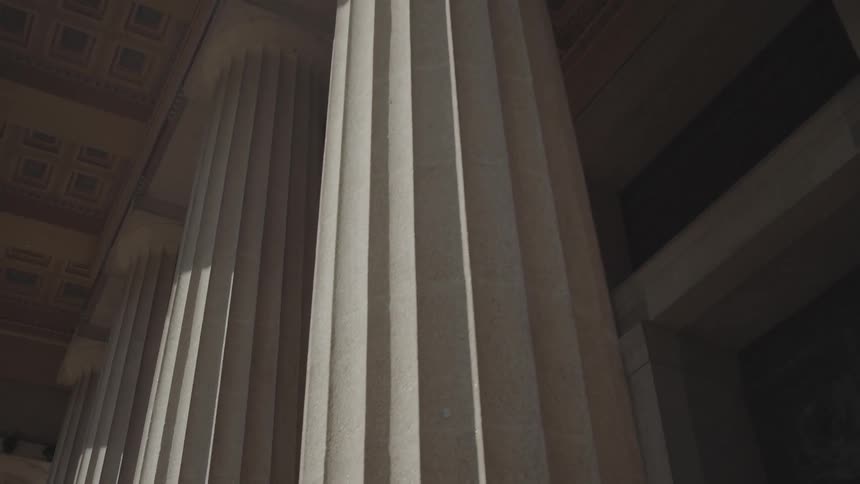 Classical columns with vertical fluting beneath coffered ceiling