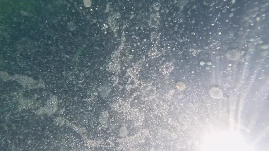 Bright light glares on foaming water