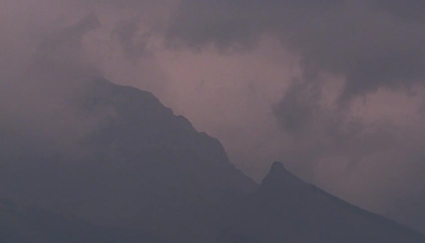 Clouds at sunset hover low over the mountains