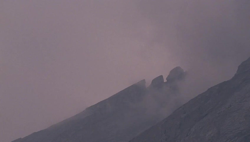Mountain peak covered in mist under soft evening light
