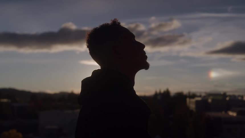 The man watches the sunrise on the roof