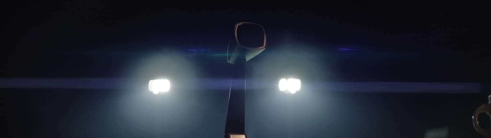 Nighttime scene with modern light poles casting strong beams through the darkness