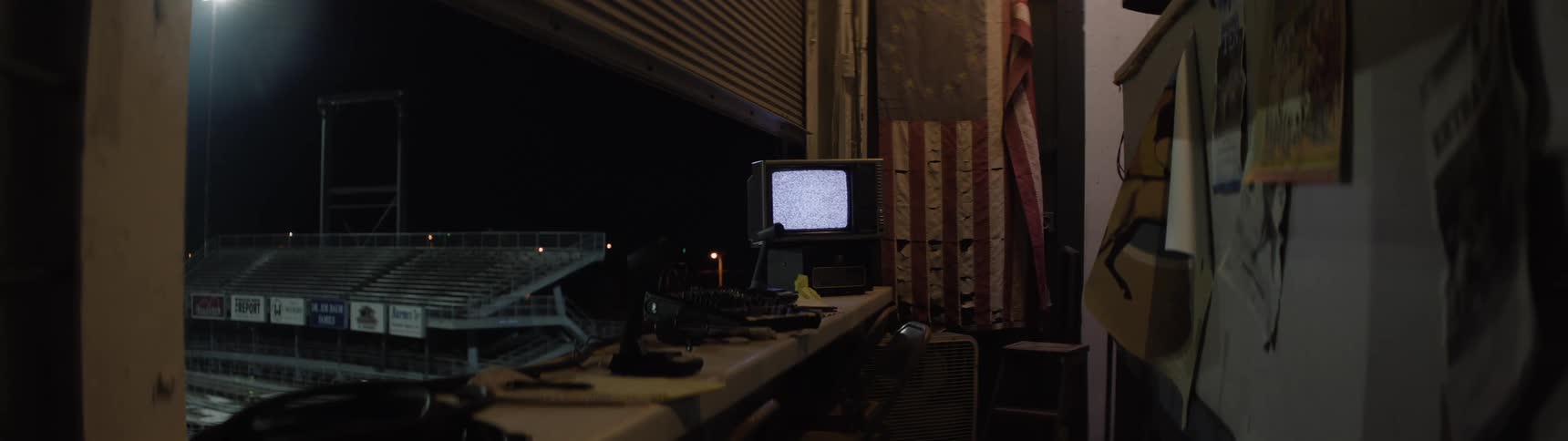Staticfilled monitor inside a stadium booth lit at night