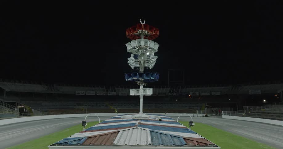 Tower of colored lights in an empty stadium lit up at night