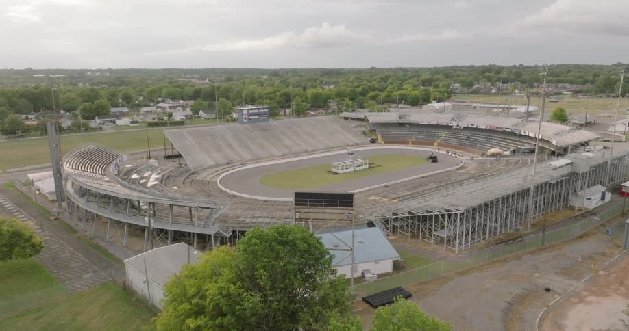 Aerial view of an empty stadium in a suburban area under an overcast sky