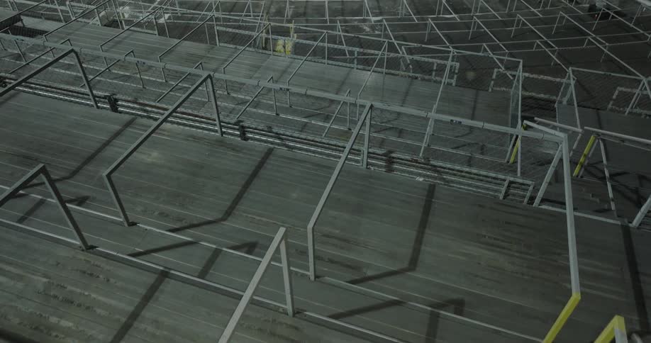 Electric light flashes across mesh enclosed seating during the evening