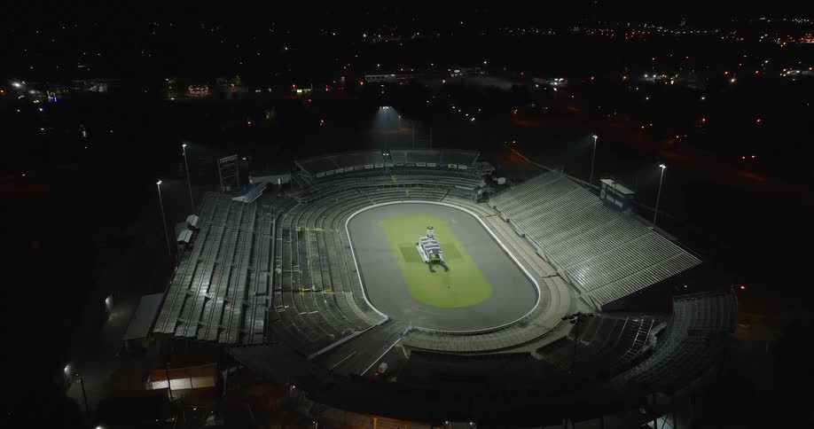 Empty stadium illuminated at night from an aerial view
