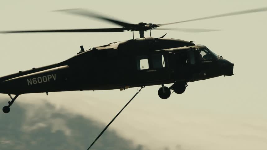 The rescue helicopter flies over the forest fire