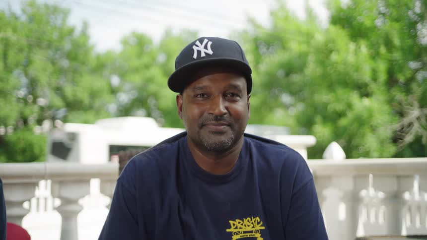 Close up portrait of a middle aged black man sitting outdoors in a suburban city