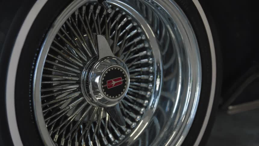 Chrome wirespoke rim with whitewall tire showcasing classic automotive style