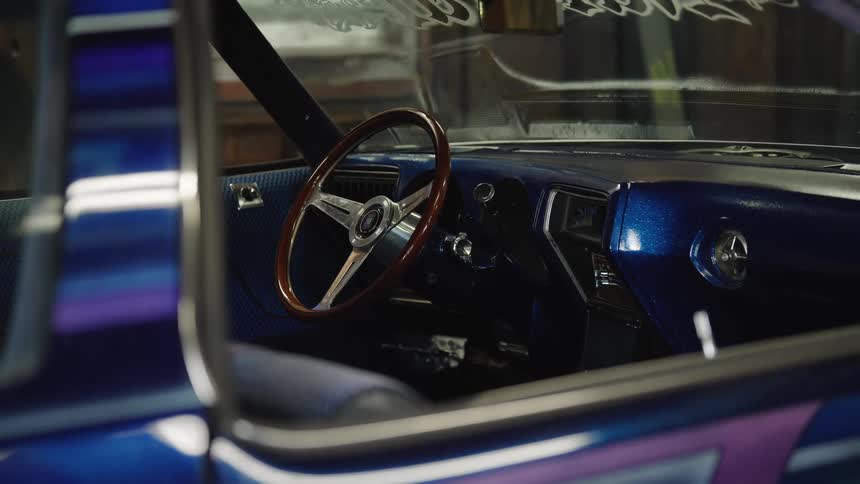 A spotless brandnew car is parked inside a garage at midday