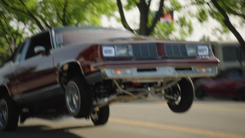 Hydraulic car jumping with its front wheels lifted on the street