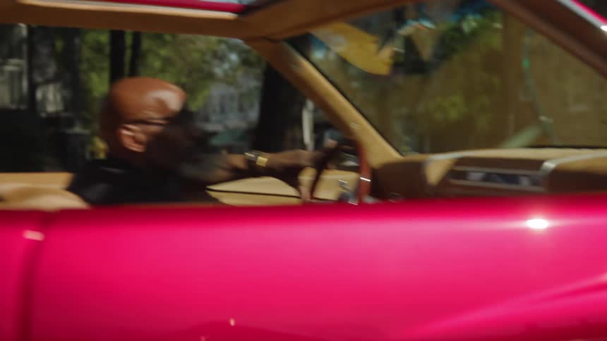 The man driving turns to his side and gives a peace sign