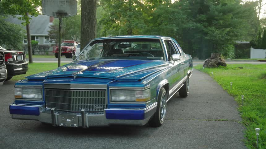 A blue cadillac parked in a driveway