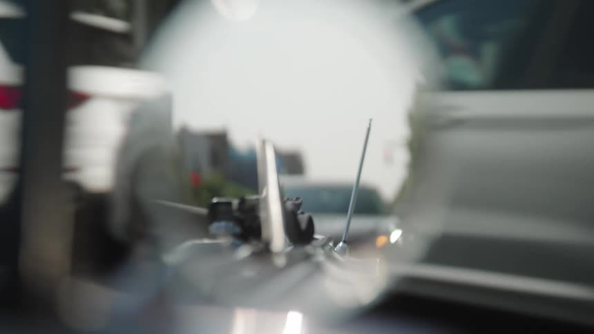 A sideview mirror reflecting a car in the back