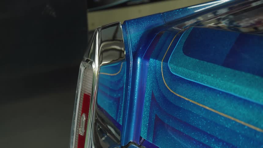 Close up of the rear lights of a blue vintage vehicle parked in a garage