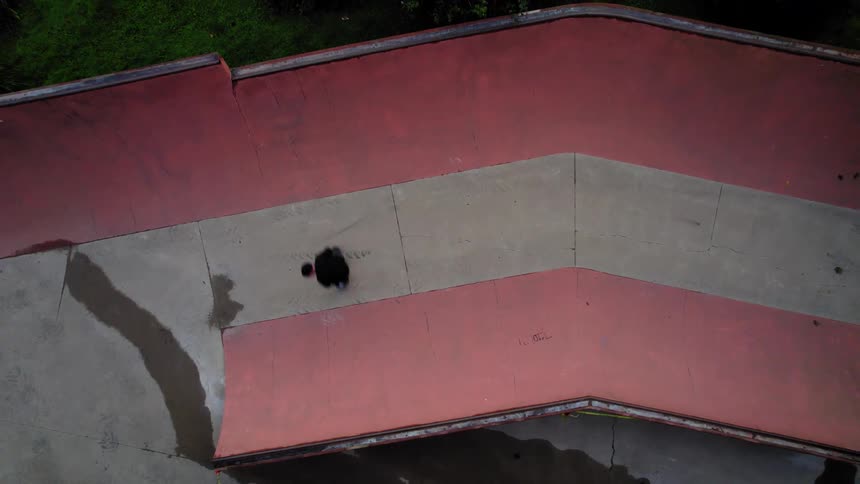 Skateboarder performing on a skate ramp with red curved walls