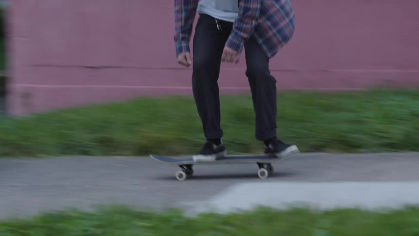 A man wearing a beanie skateboarding and performing a trick on the street