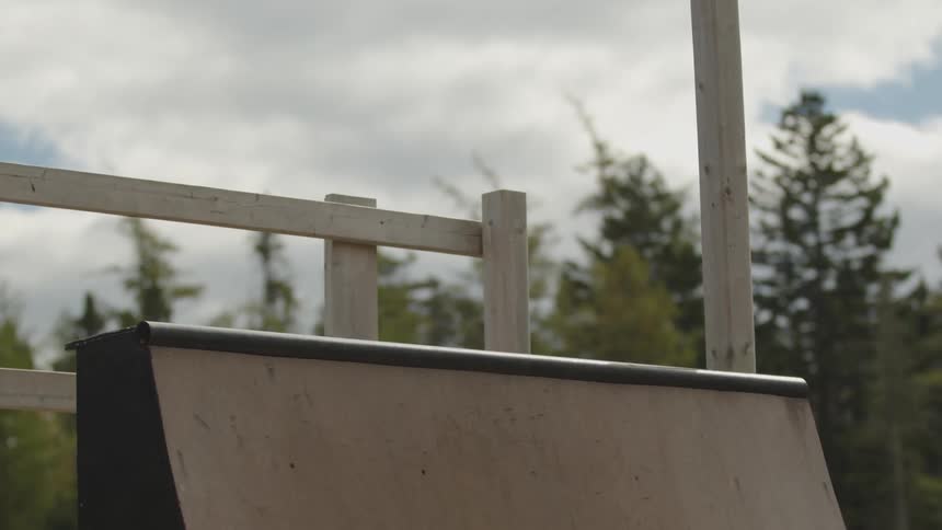 The teenager jumps on the ramp while skating