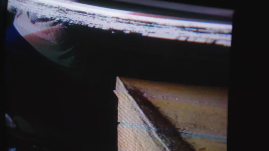 Recording of a person performing a skate trick shown on a screen