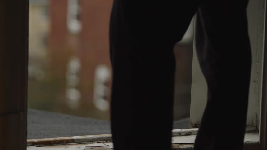 The man climbs out the window