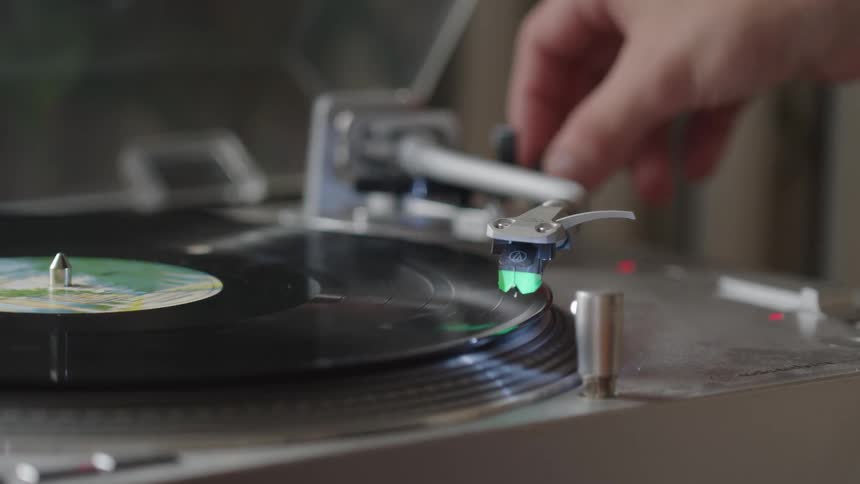The man plays a record on the record player