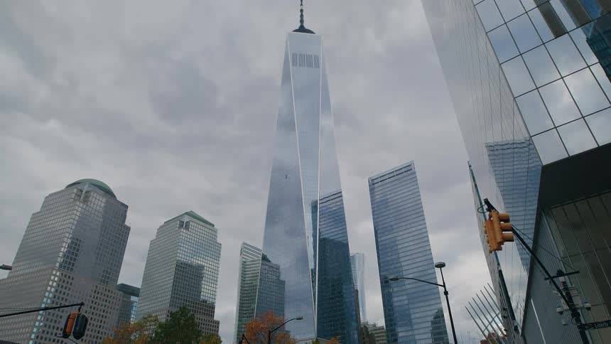 Pedestrians walk past the tall buildings