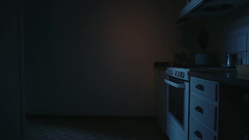 Oven and cabinets on the right in a dimly lit kitchen