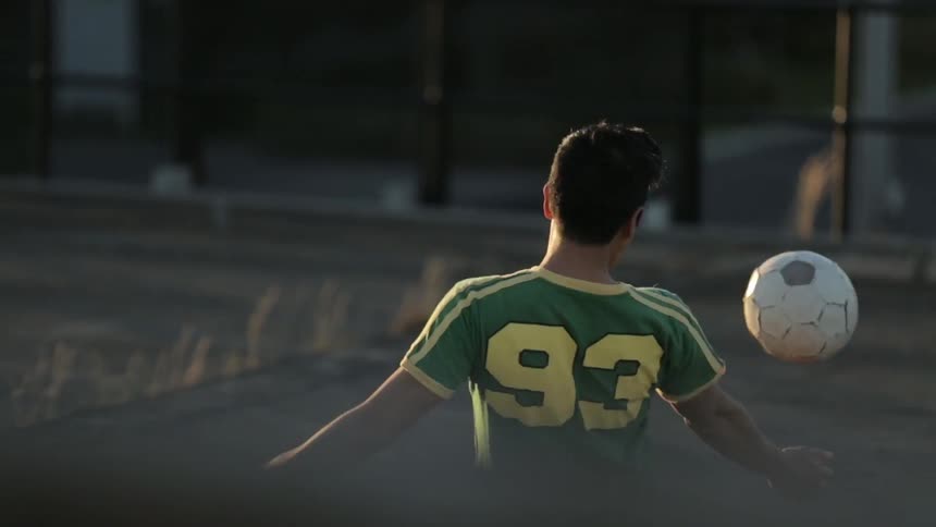 A man juggles a soccer ball on his knee, but then the ball gets away and he runs after it