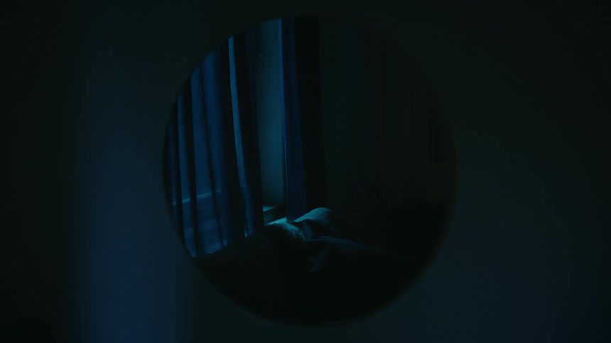 The mirror is reflecting the person in bed
