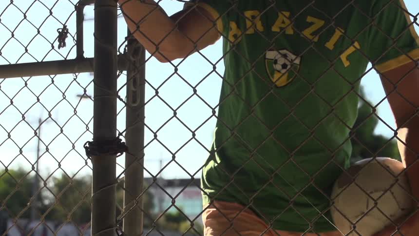 Man unchaining a fence then opening it