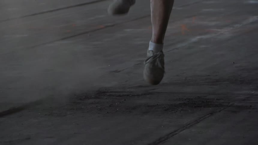 A person comes up and kicks a soccer ball